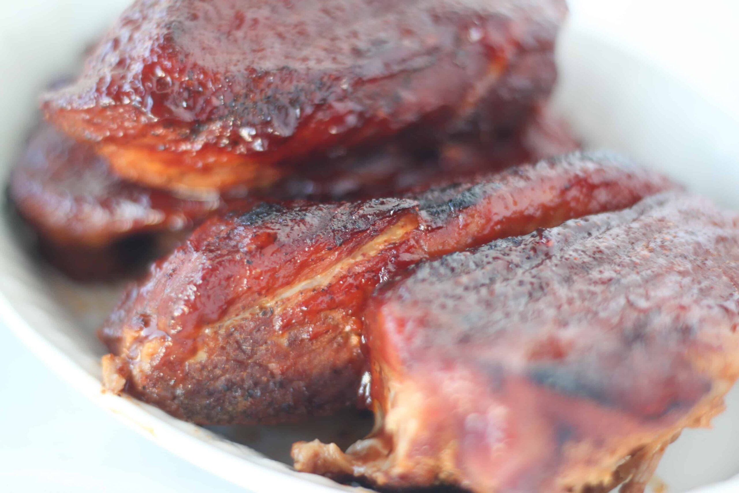 country style ribs pressure cooker recipe with a side angle photo of the ribs after adding more BBQ sauce