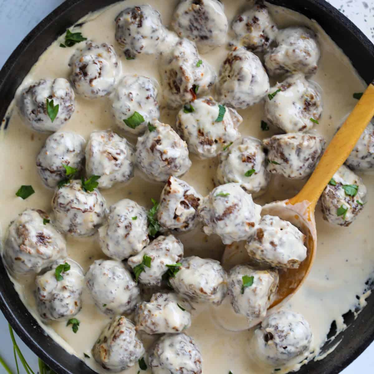 gluten free swedish meatballs with whipping cream in a skilet