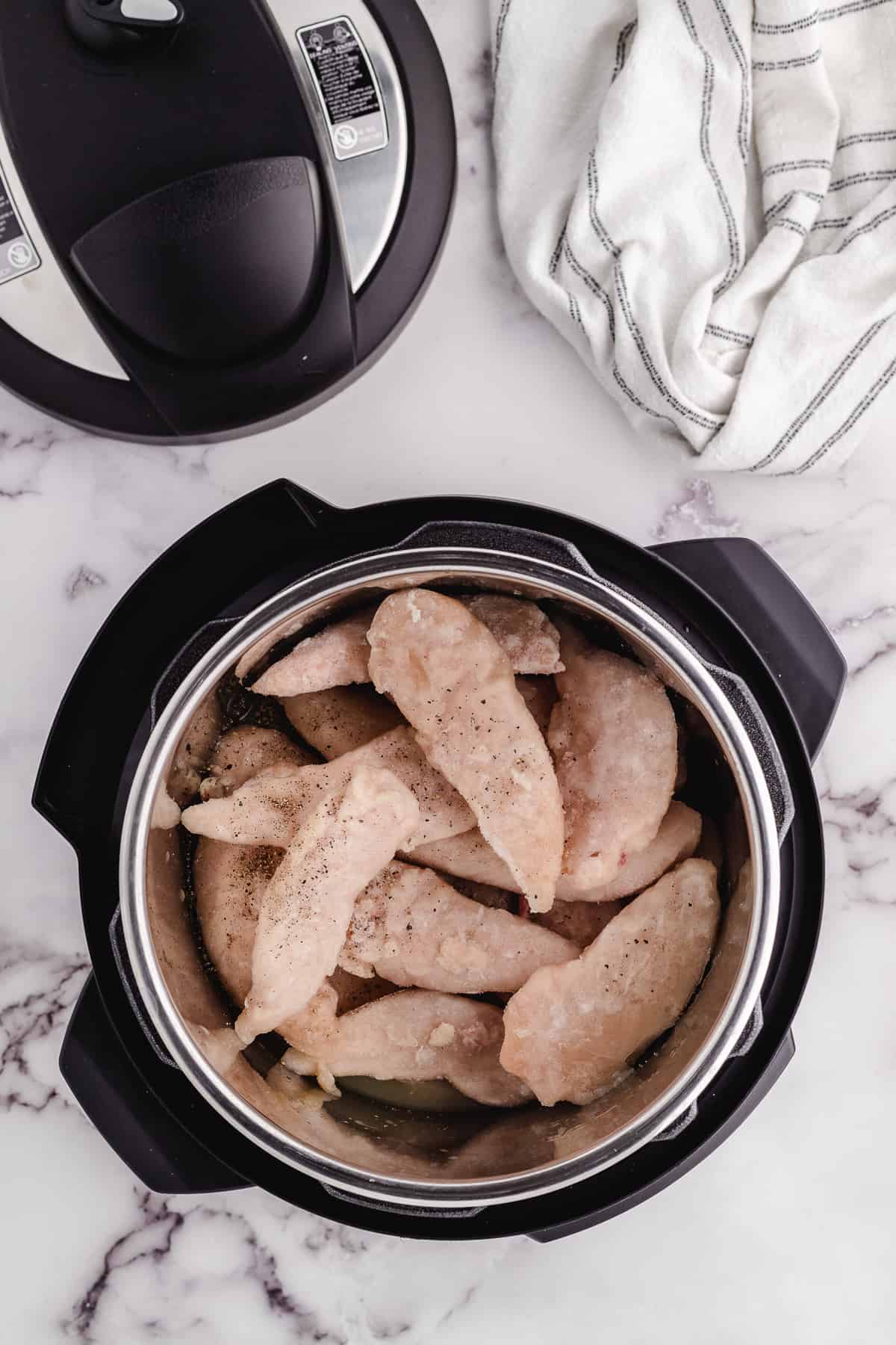 instant pot frozen chicken tenders getting put in the pressure cooker