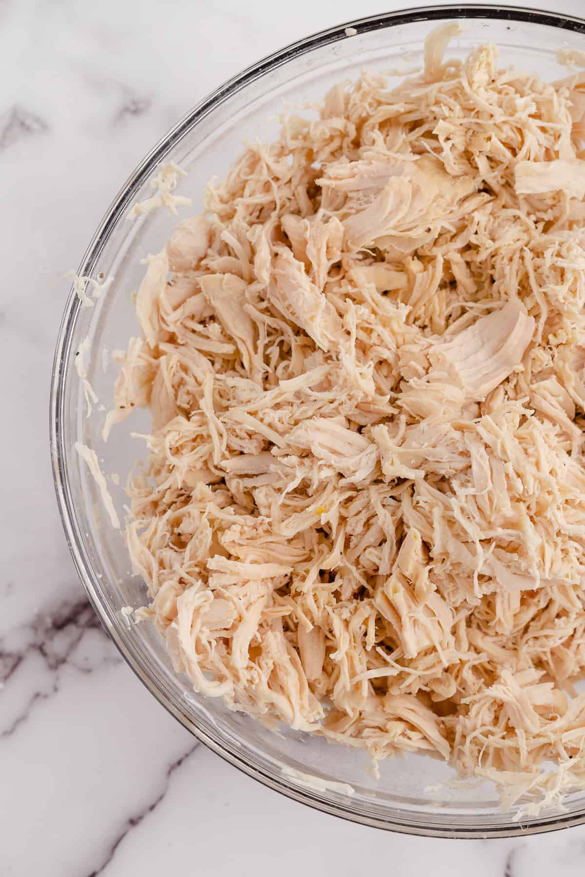 chicken in a bowl after shredding chicken with a kitchenaid mixer