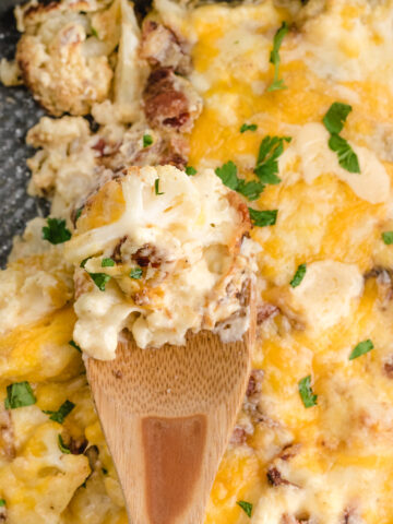 cauliflower casserole with bacon close up on a spoon after baking