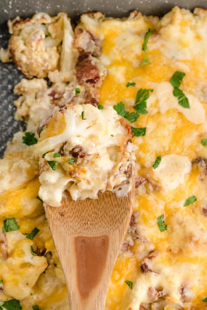 cauliflower casserole with bacon close up on a spoon after baking