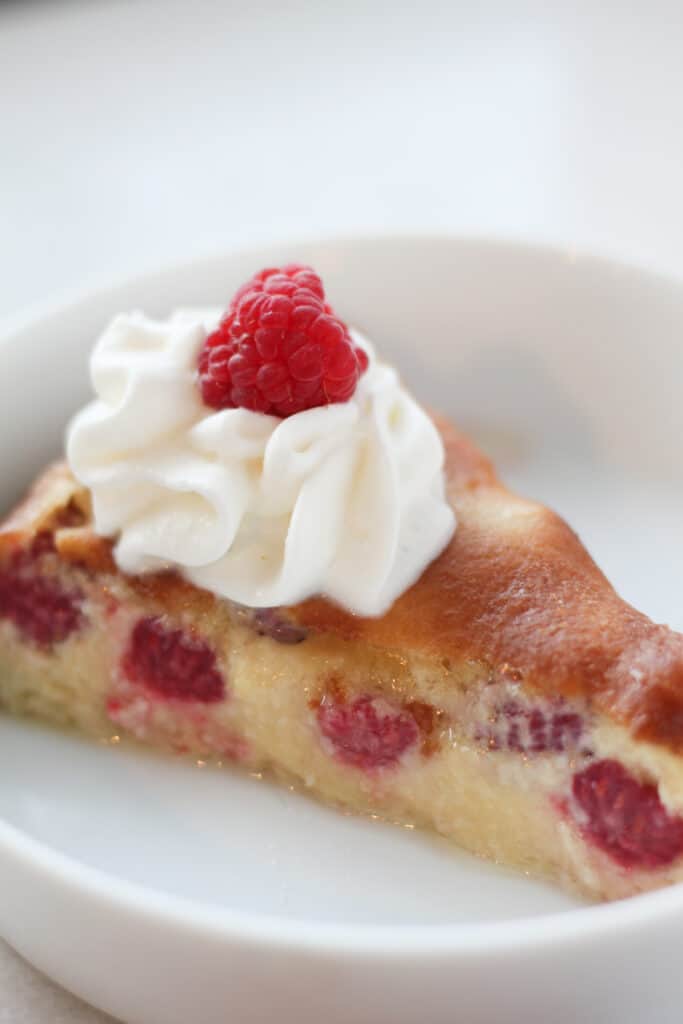 keto crustless egg custard pie with raspberries with a slice of pie in a dish