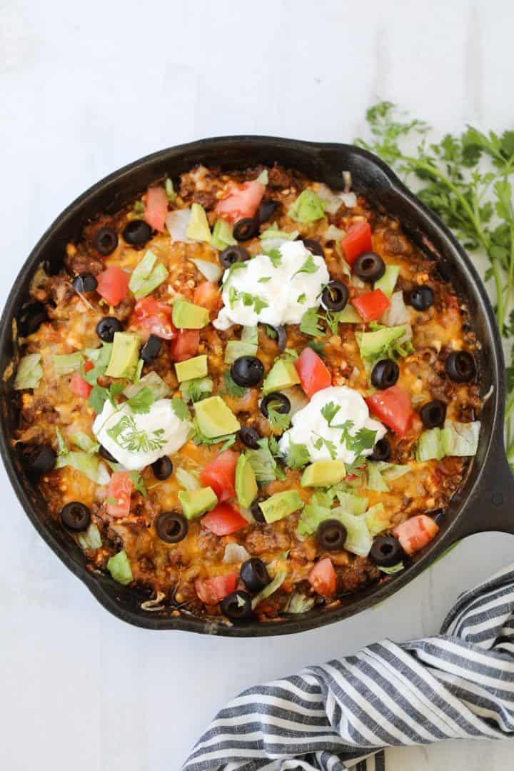 keto mexican casserole with taco toppings served in a cast iron skillet
