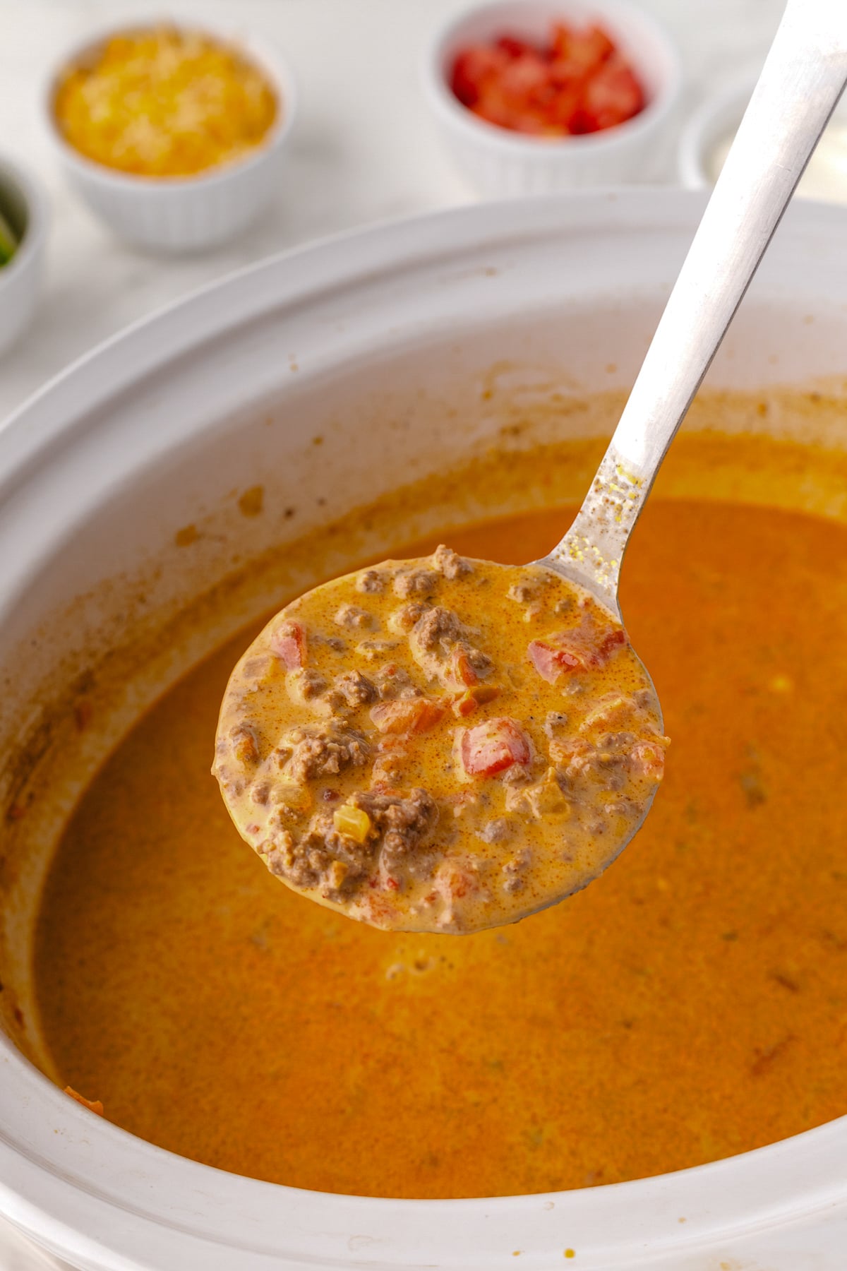 scooping the low carb taco soup onto a spoon after cooking
