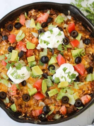 mexican taco casserole with garnishes in the pan