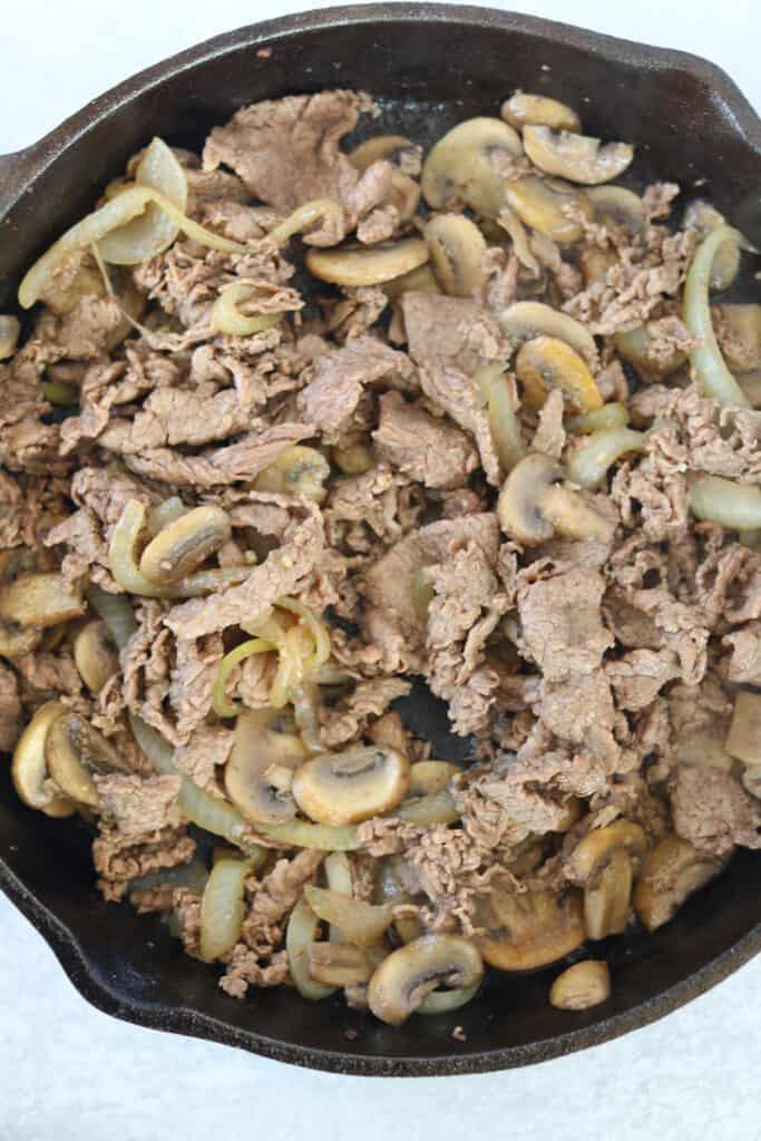 saute the steak, mushrooms, and onions in a pan to make steak stuffed peppers