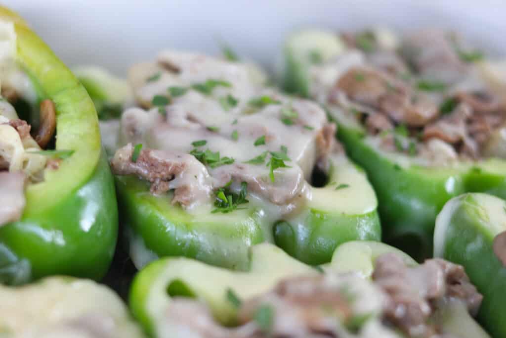 keto cheesesteak stuffed peppers partially cooked with cheese starting to melt