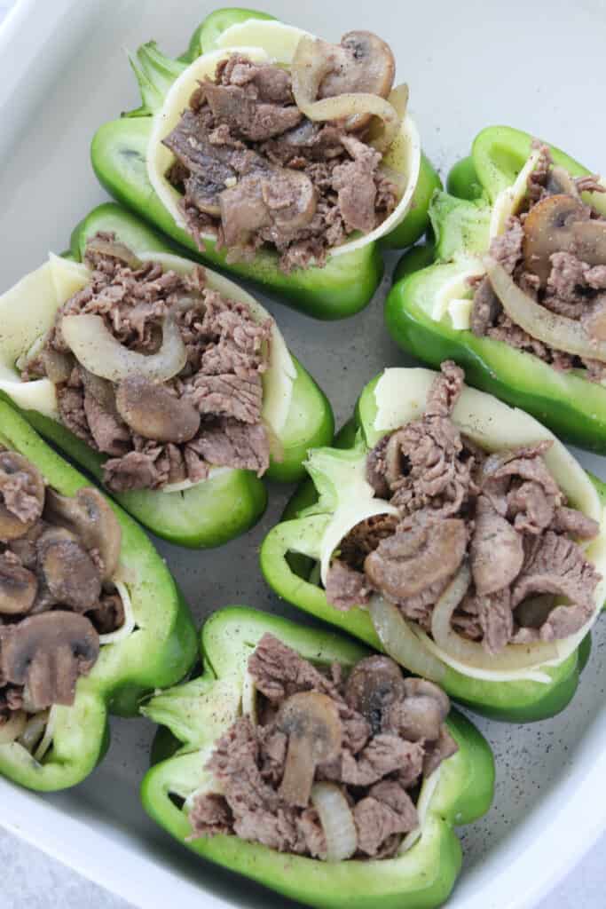 Philly cheese stuffed peppers in a pan before adding the cheese on top and baking