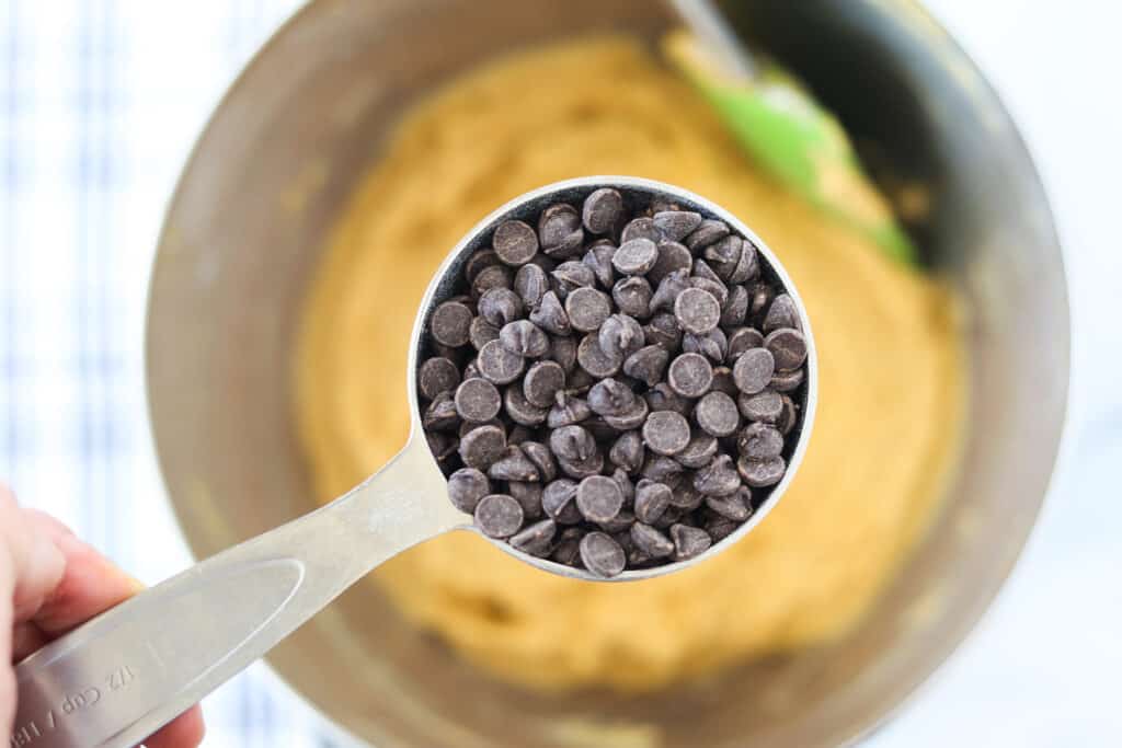 low carb pumpkin chocolate chip muffins getting made with the batter in a bowl and the chocolate chips getting added