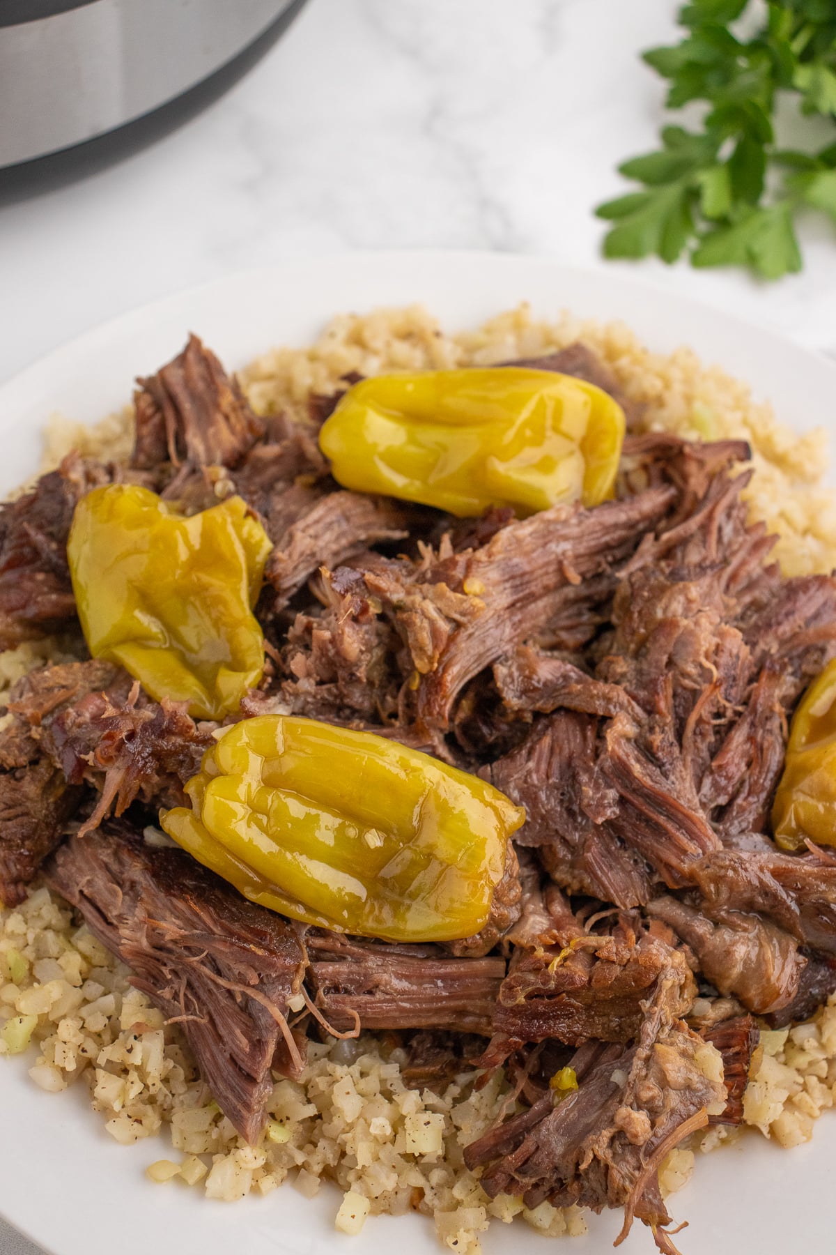 beef chuck roast on a plate shredded with hot peppers and rice