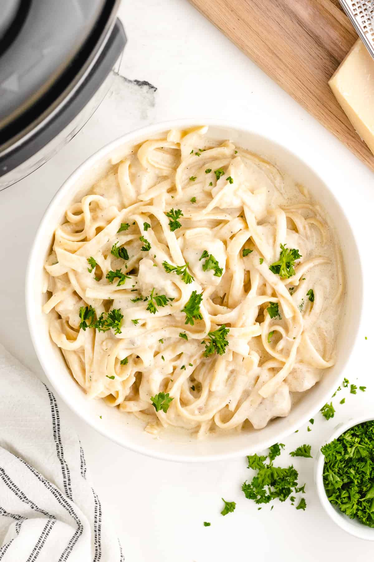 instant pot chicken alfredo looking down on white board with parsley garnish