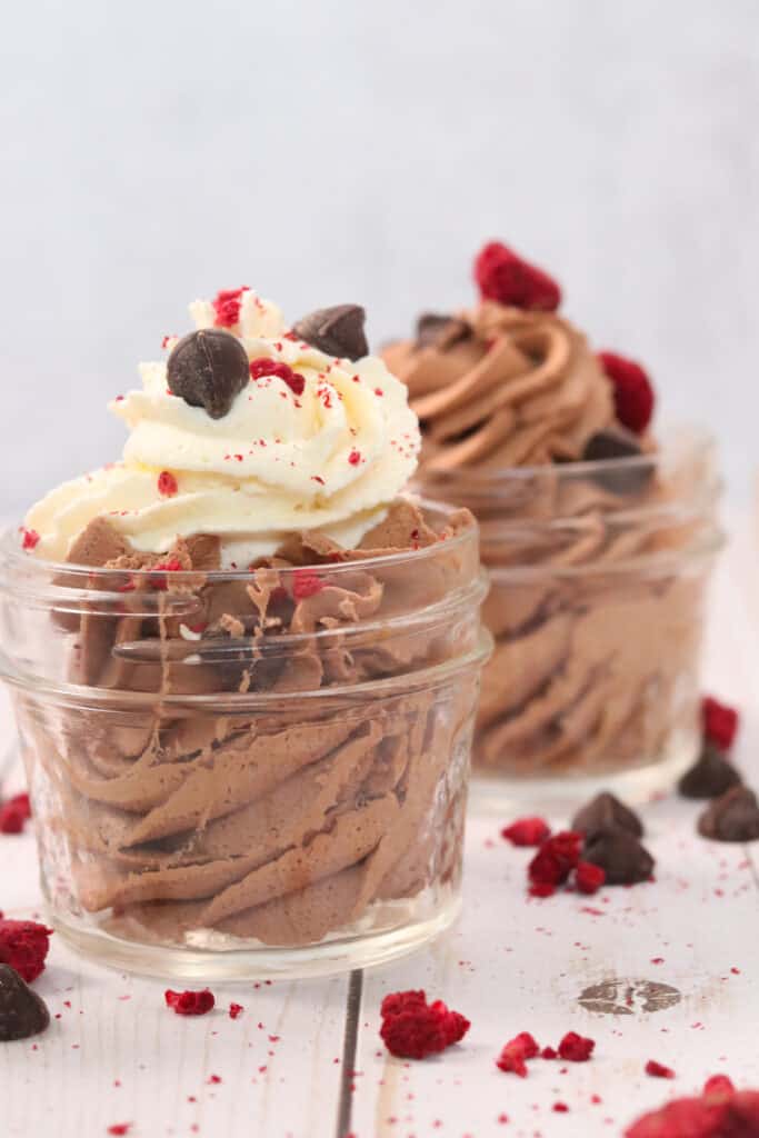 keto chocolate mousse recipe with two bowls ready to serve with toppings and cream