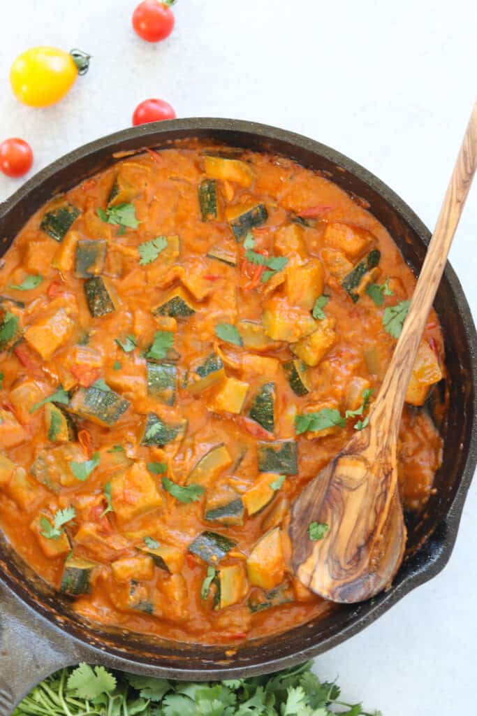 the zucchini curry in a pan after cooking top down view is also a thai red curry vegetarian recipe