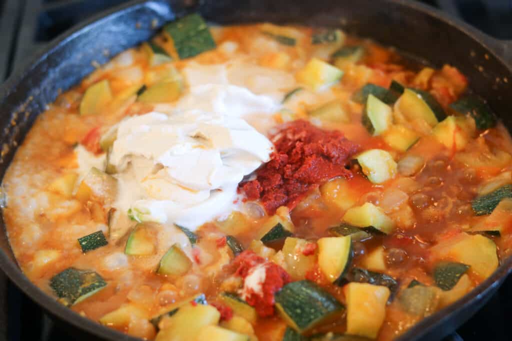 Adding the curry paste and coconut milk after the vegetables have cooked for vegan red curry