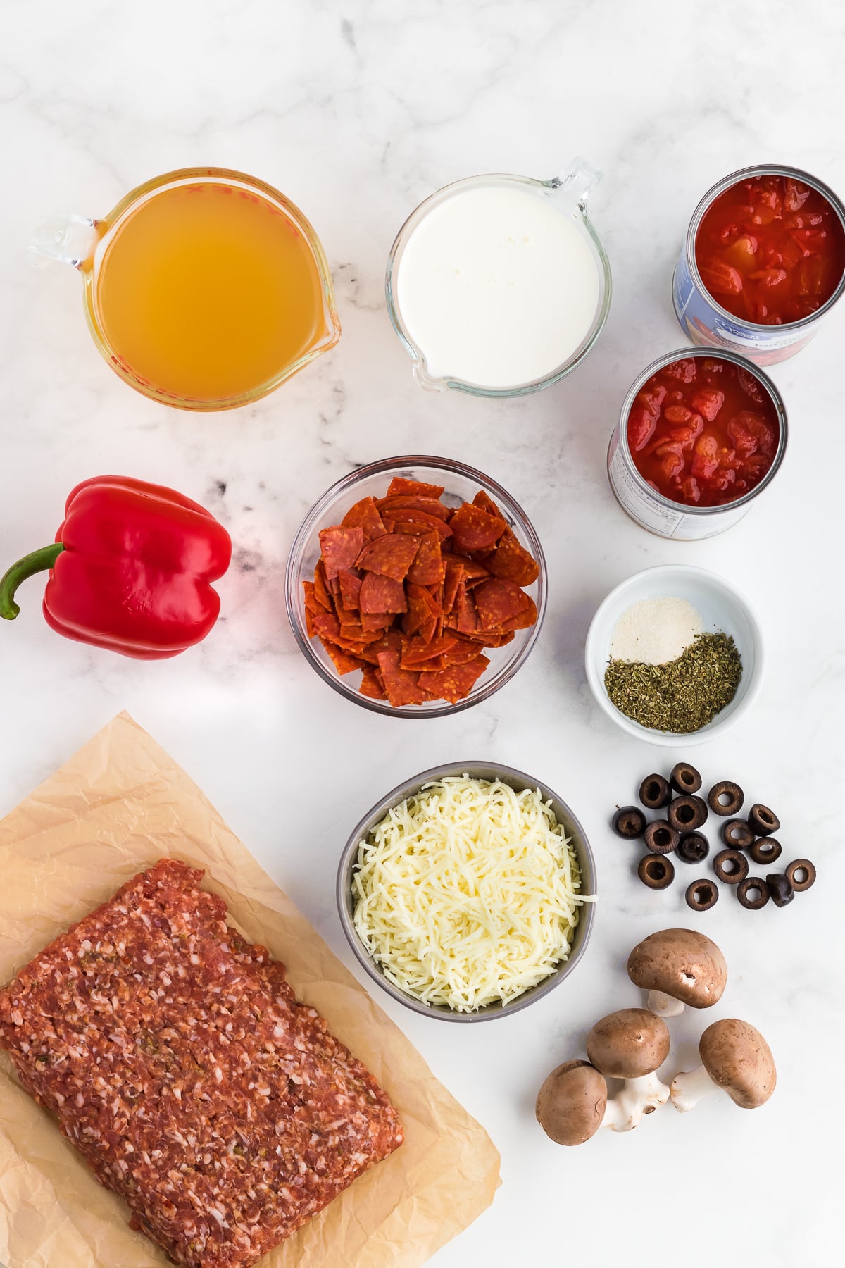 pizza soup ingredients on a white marble backdrop