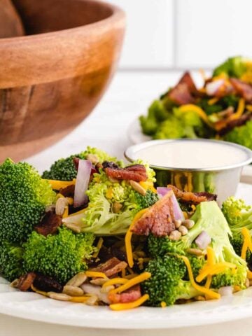 cold broccoli salad on a plate next to the salad bowl