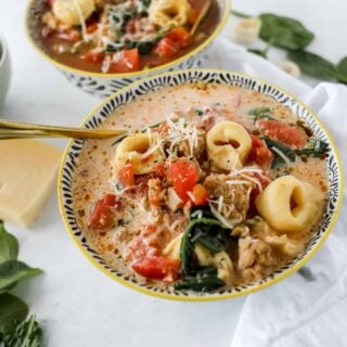 a creamy tortellini soup crockpot recipe with a spoon in the bowl ready to eat