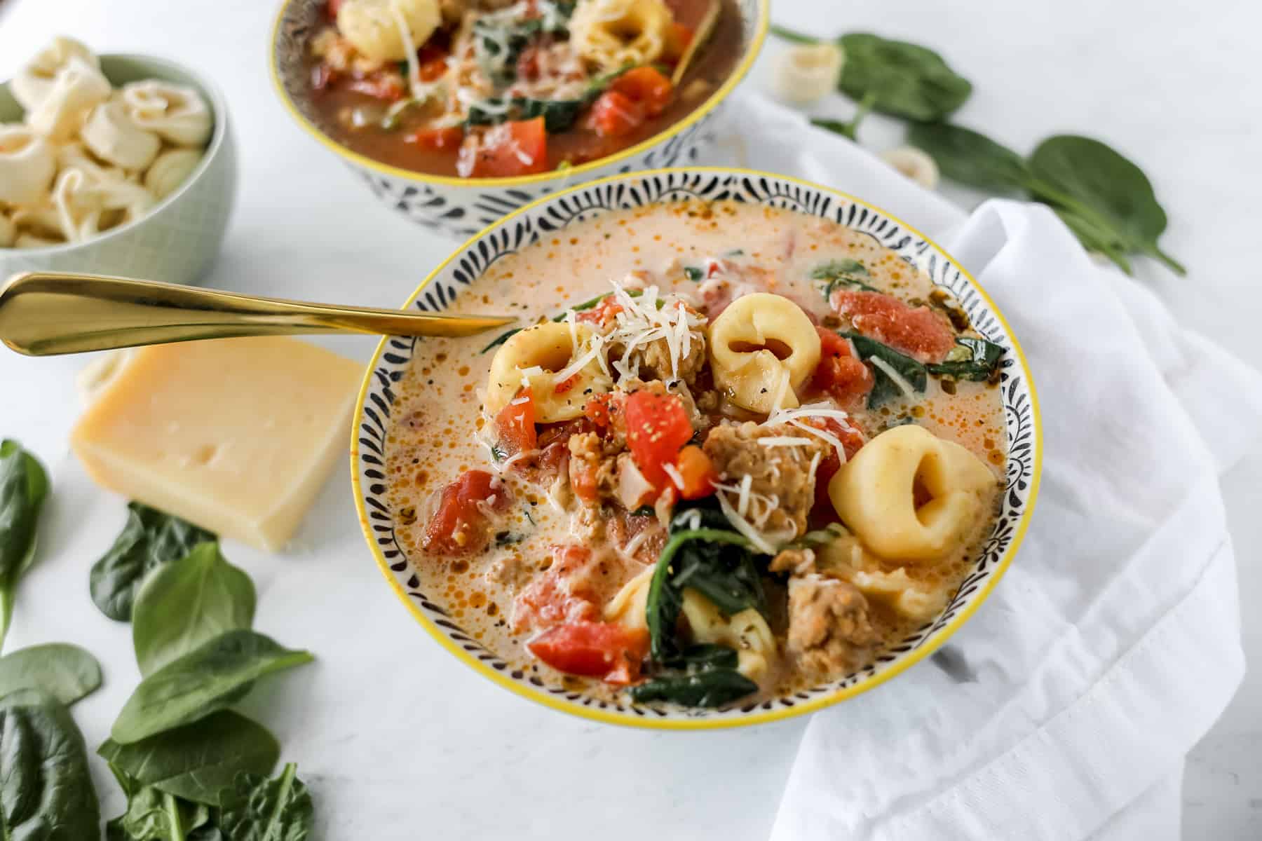 a creamy tortellini soup crockpot recipe with a spoon in the bowl ready to eat