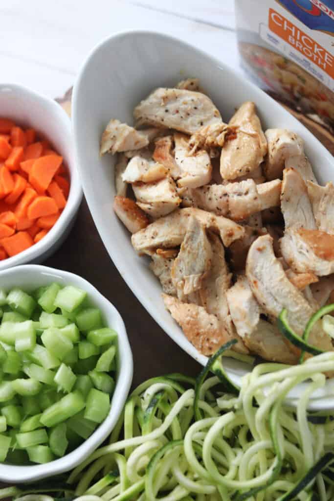 keto chicken zoodle soup ingredients on a white background