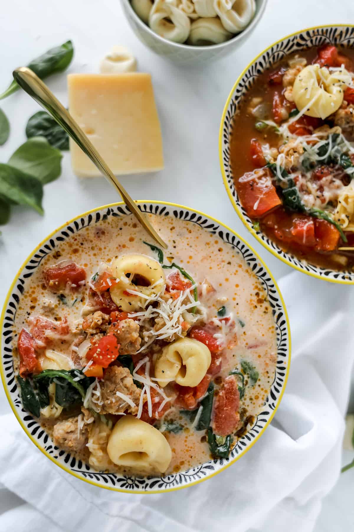 sausage tortellini soup crock pot recipe in two bowls, one creamy and one without cream