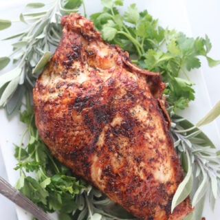 air fryer turkey breast cooked and surrounded with herbs