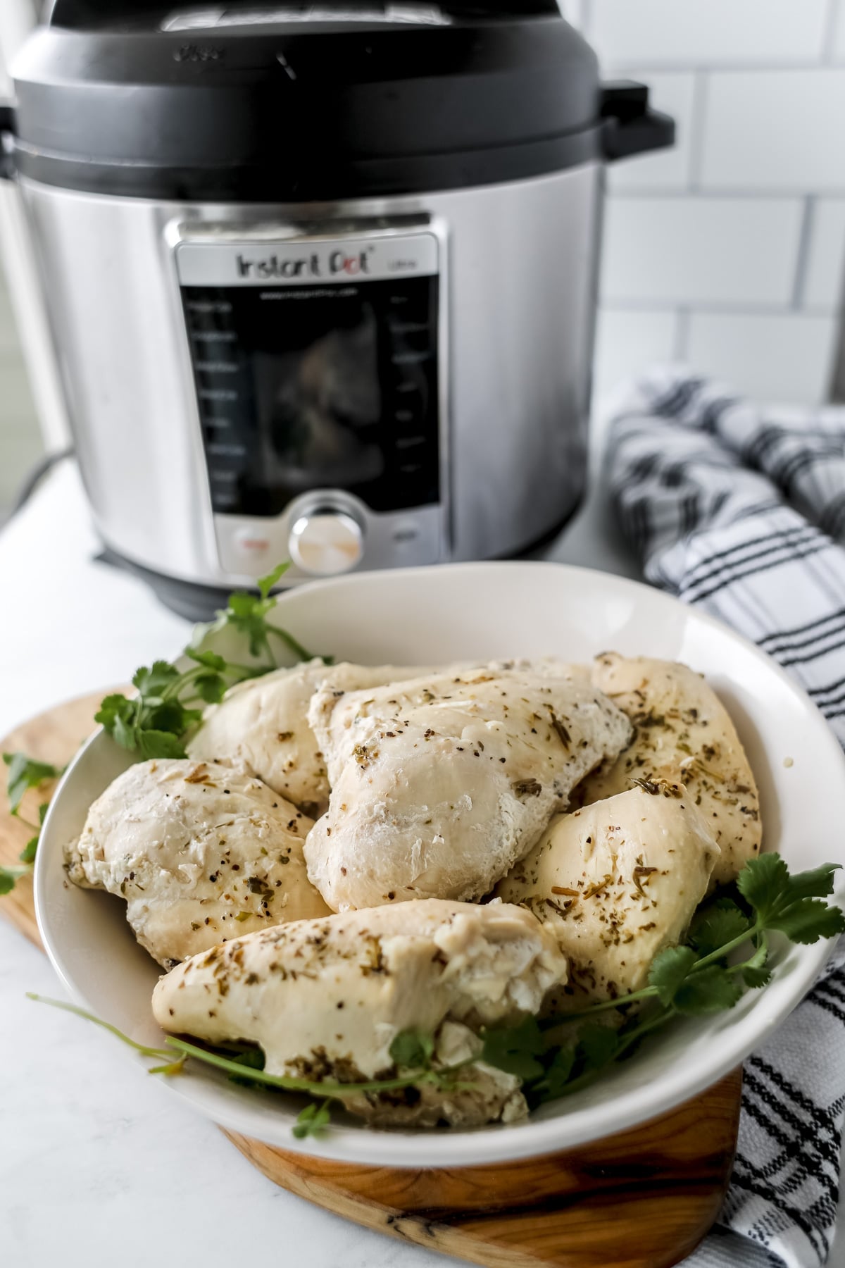 instant pot frozen chicken breast with cooked chicken in a white bowl