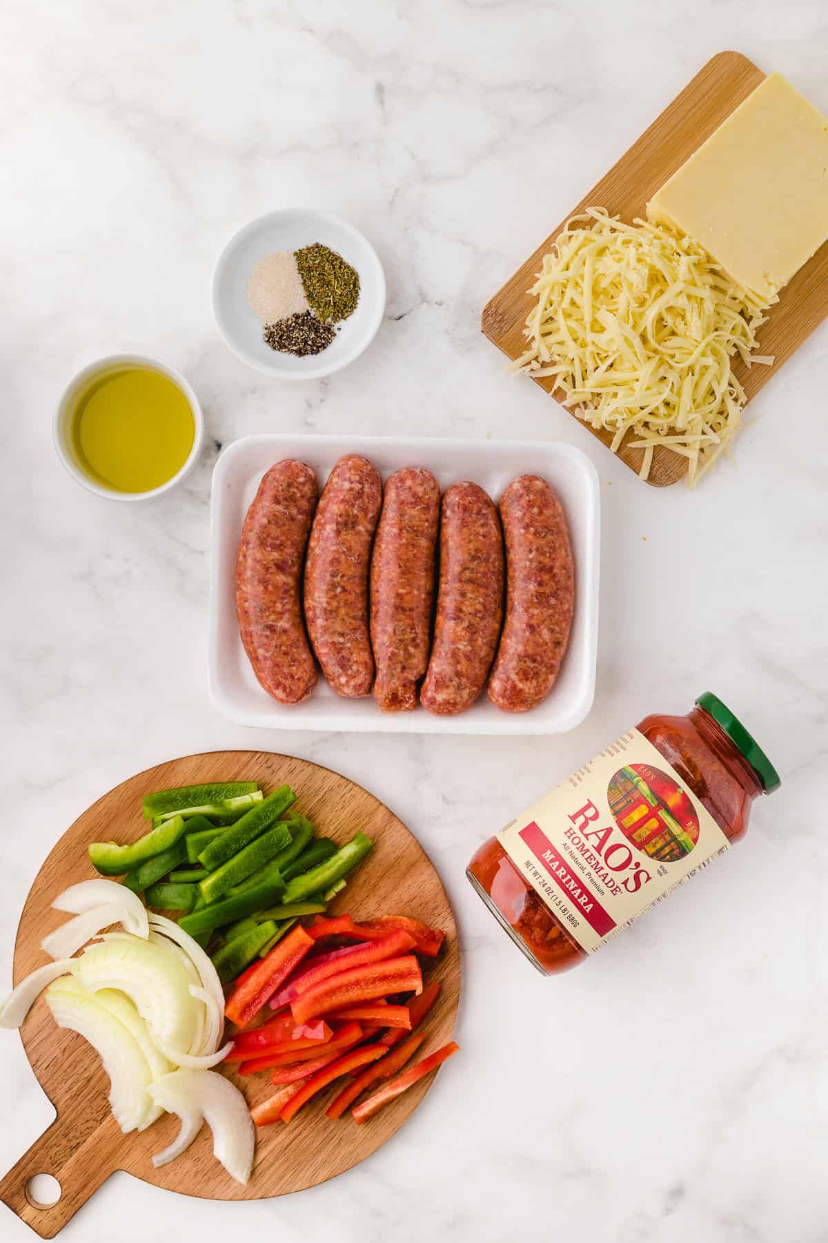 Italian sausage bell peppers and the other ingredients on a white marble background
