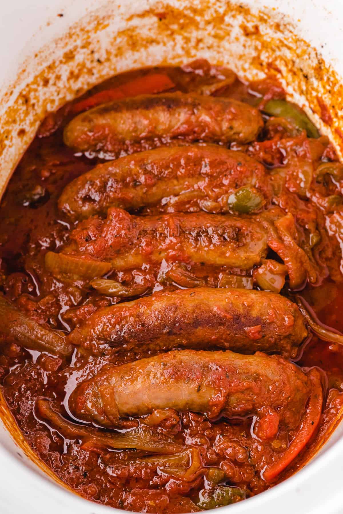 cooked italian sausage with sauce in the slower cooker