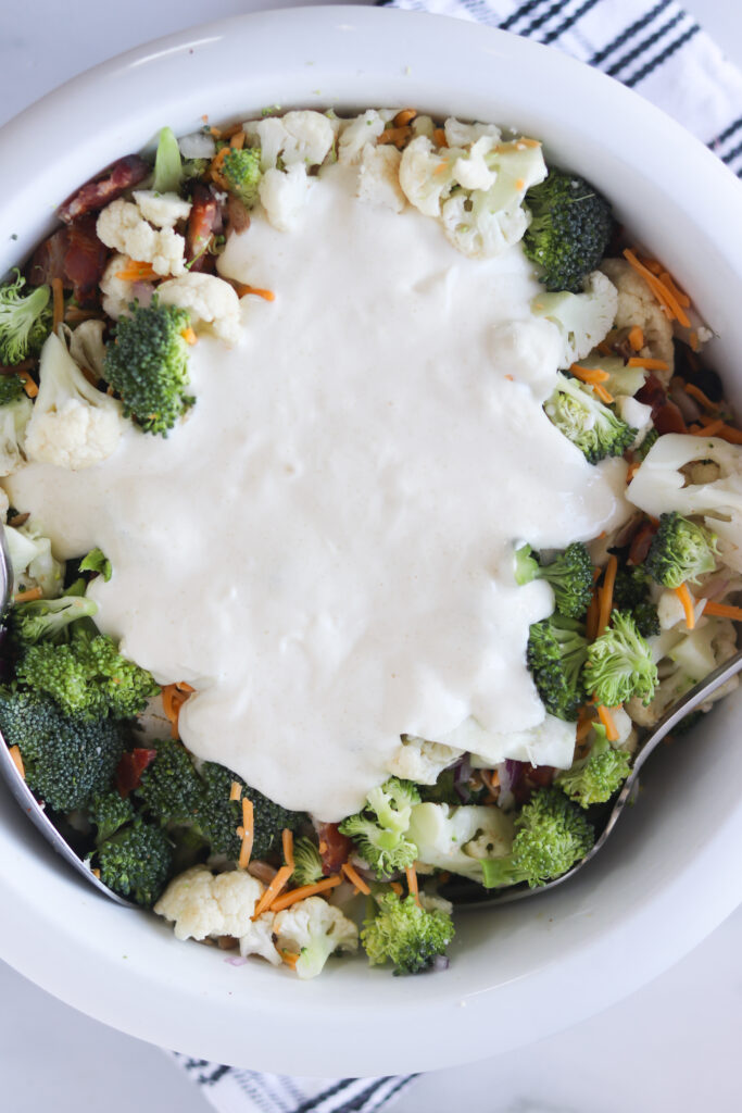 broccoli-cauliflower-bacon-mayonnaise-vinegar-salad in a bowl with dressing on top