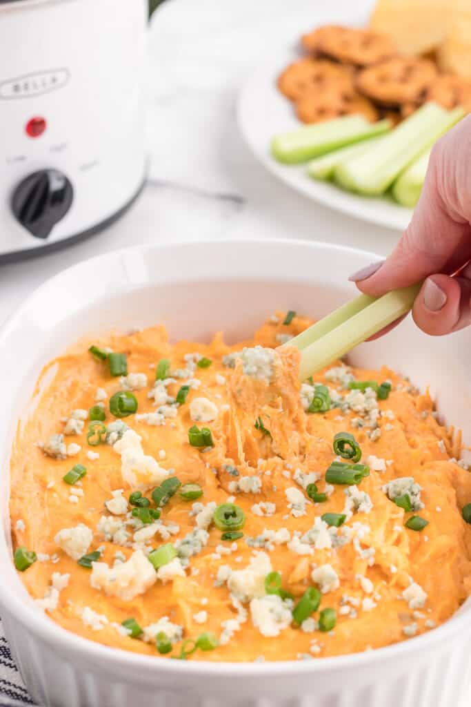dipping buffalo chicken dip with chicken breast on a celery stick