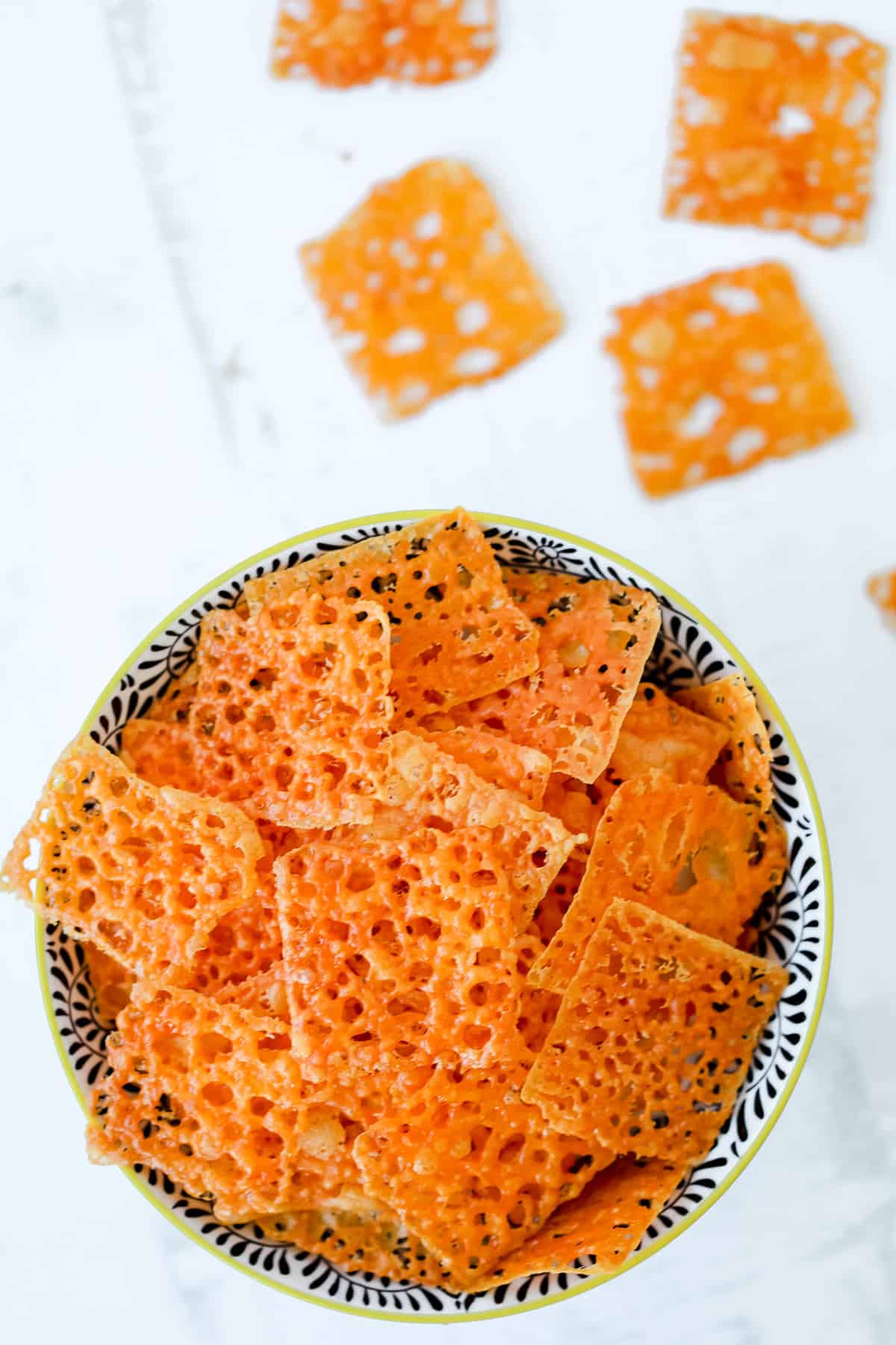 snacking on cheese crackers that were baked in the oven, piled up in a bowl on a white background