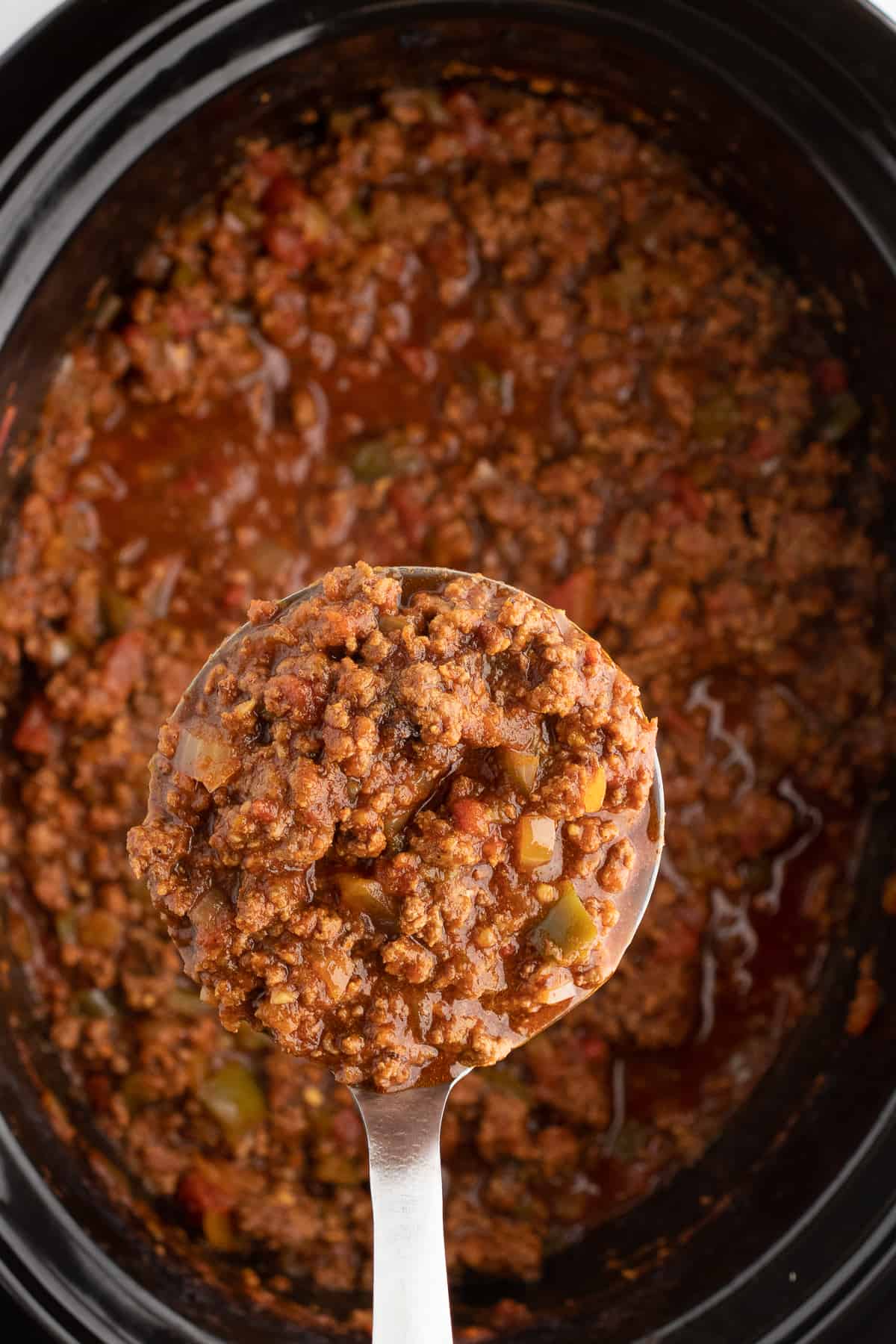 chili without beans in a crock pot on a spoon