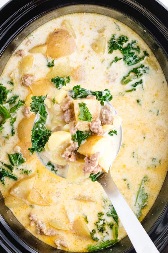 crockpot zuppa toscana with a bite on a spoon after cooking