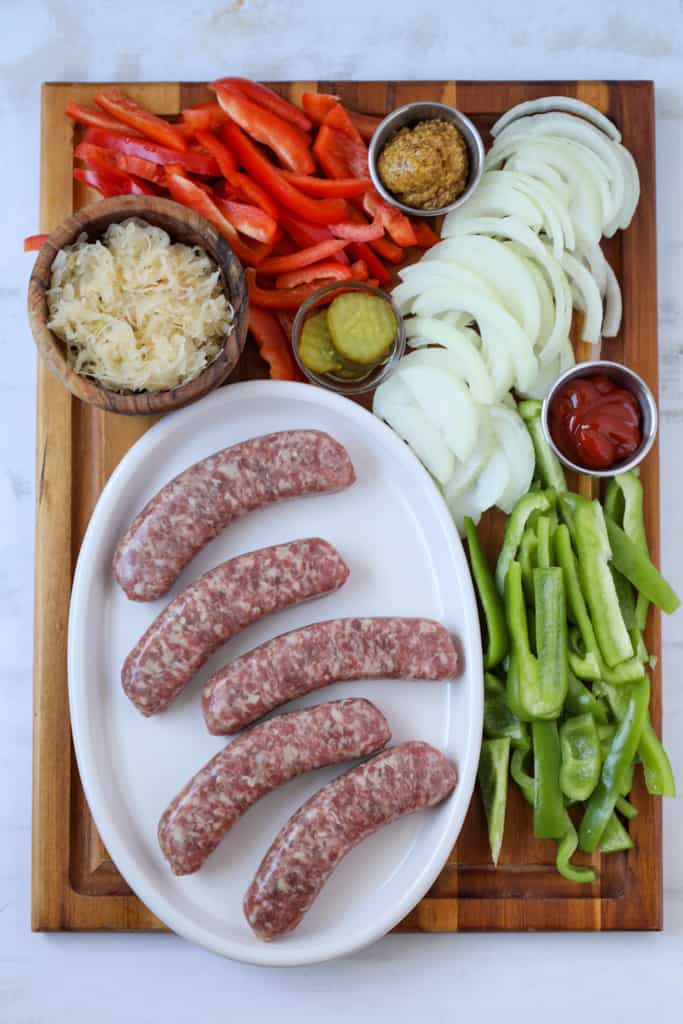 how to cook brats in oven recipe ingredients on a wood cutting board