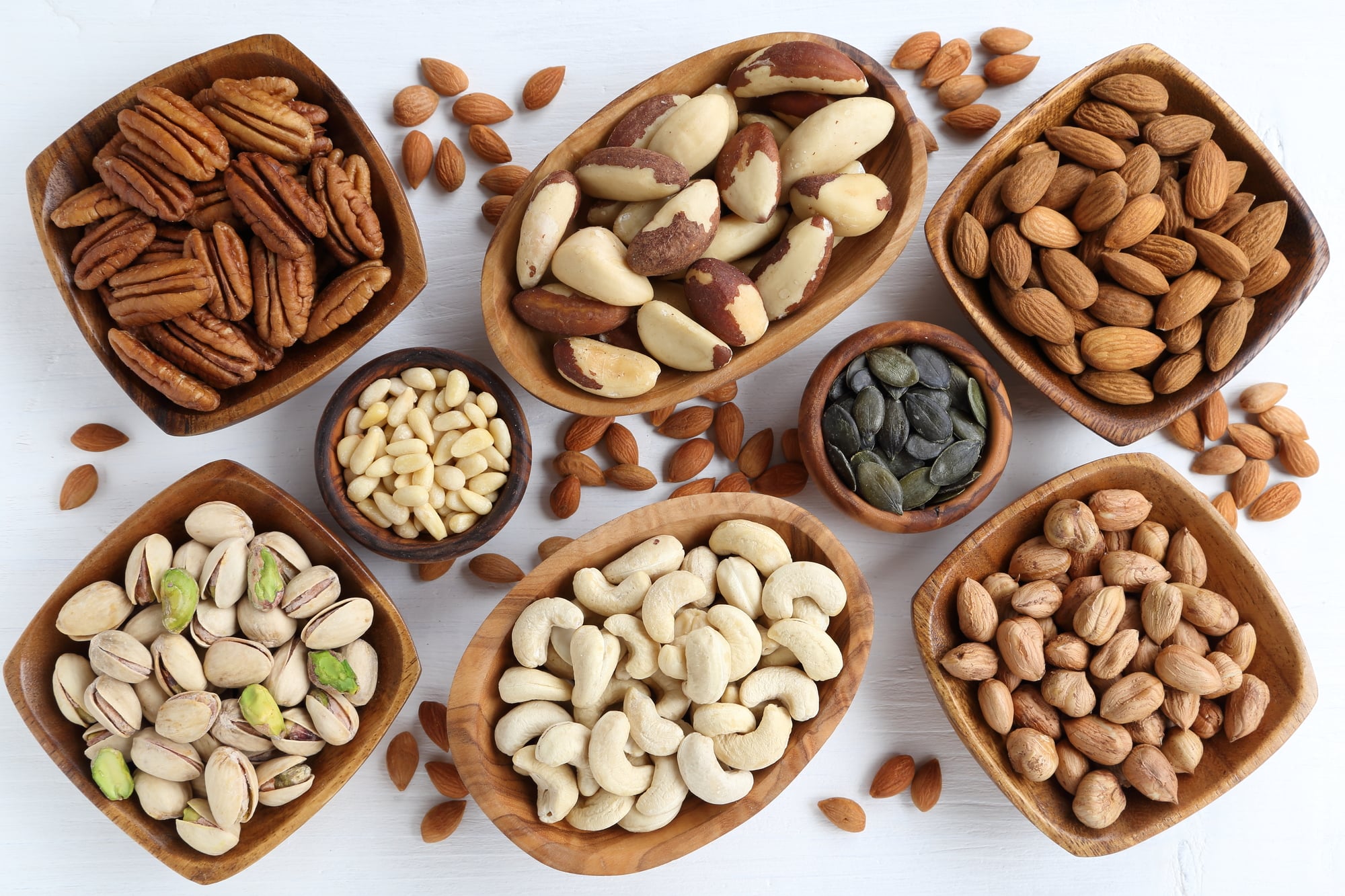 low carb nuts in wooden bowls on a white background
