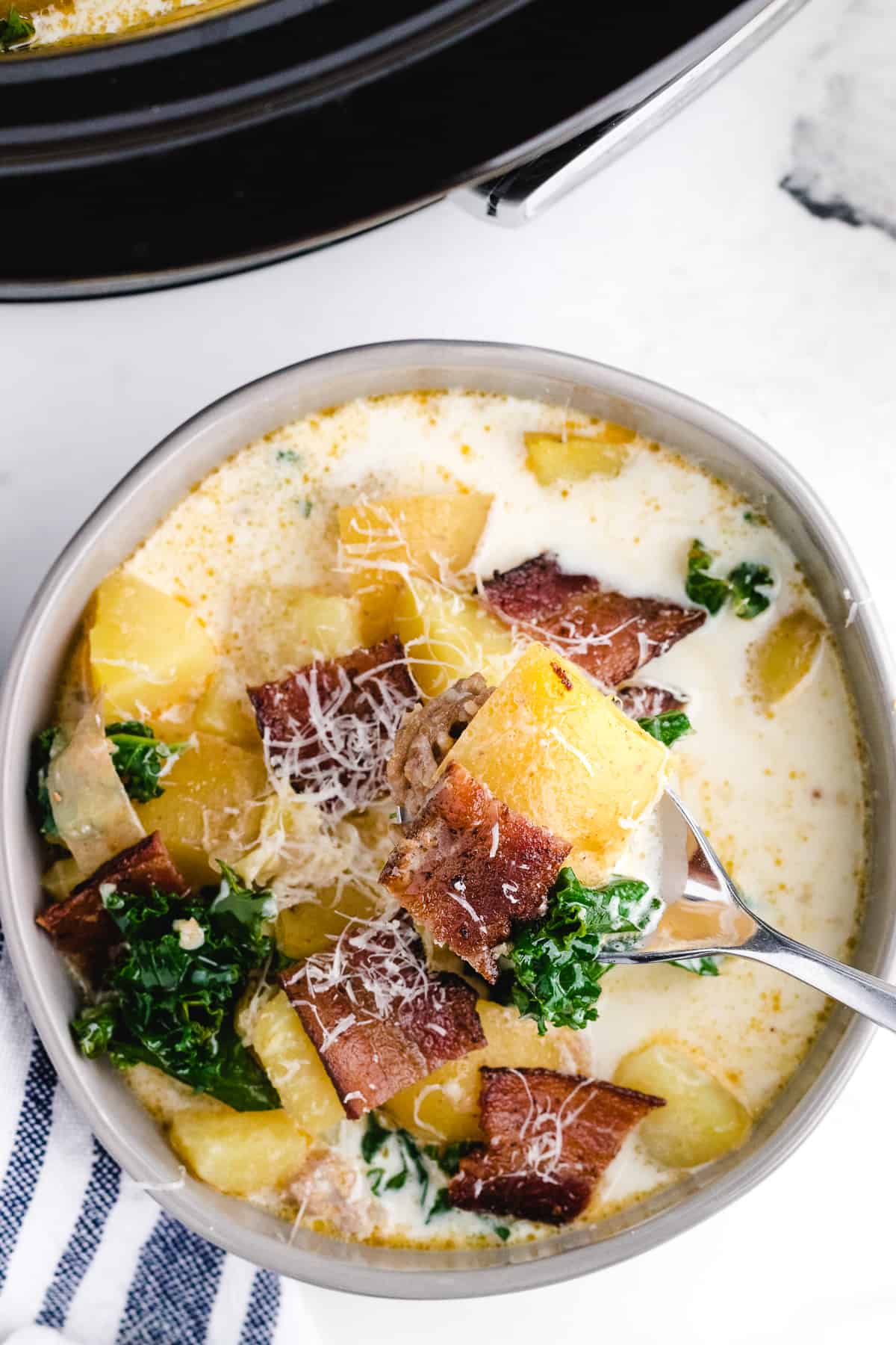 zuppa toscana crock pot recipe in a bowl garnished with bacon