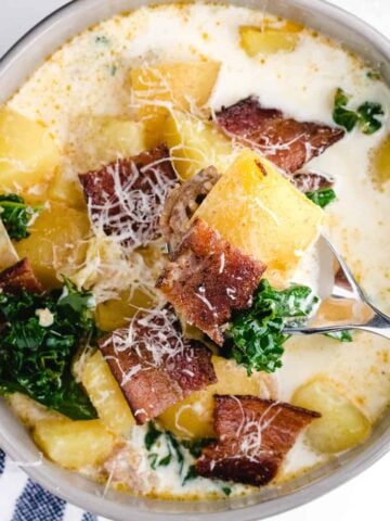 zuppa toscana crockpot in a bowl with bacon garnish