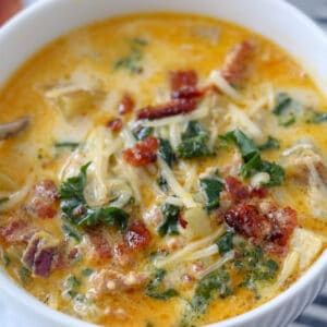 zuppa toscana soup in an instant pot served in a white bowl with bacon