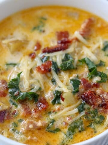 zuppa toscana soup in an instant pot served in a white bowl with bacon