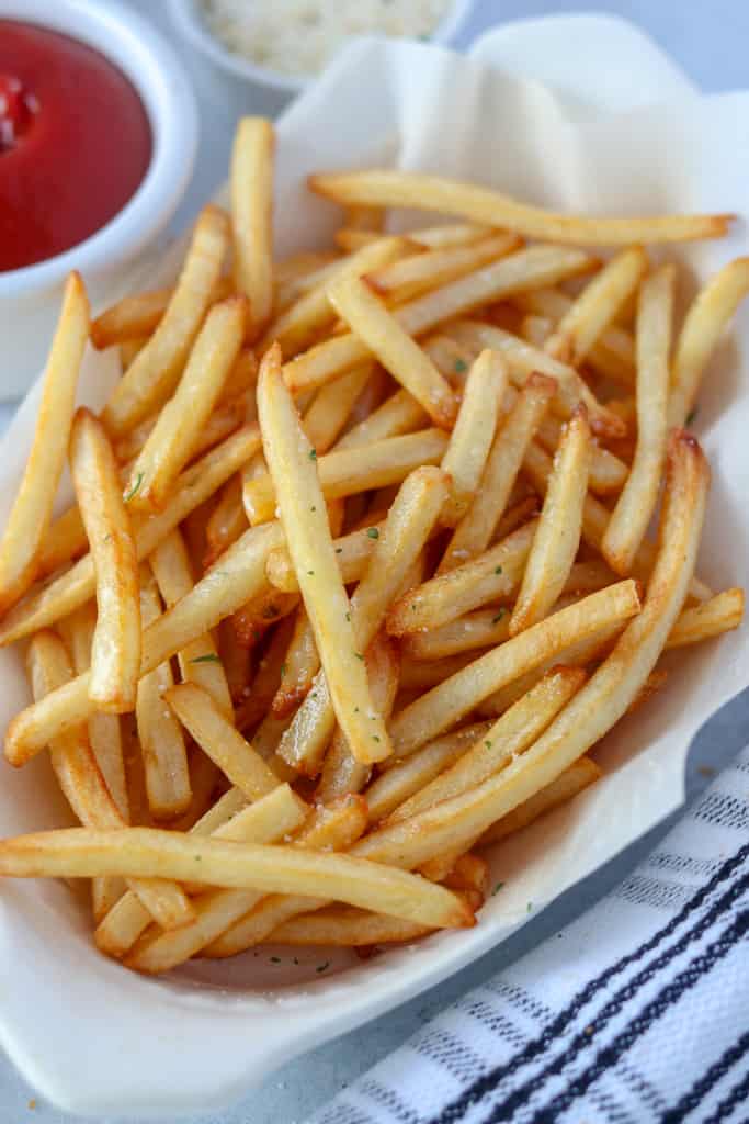 air fried frozen shoestring fries crispy and cooked in a white dish with a side of sauce