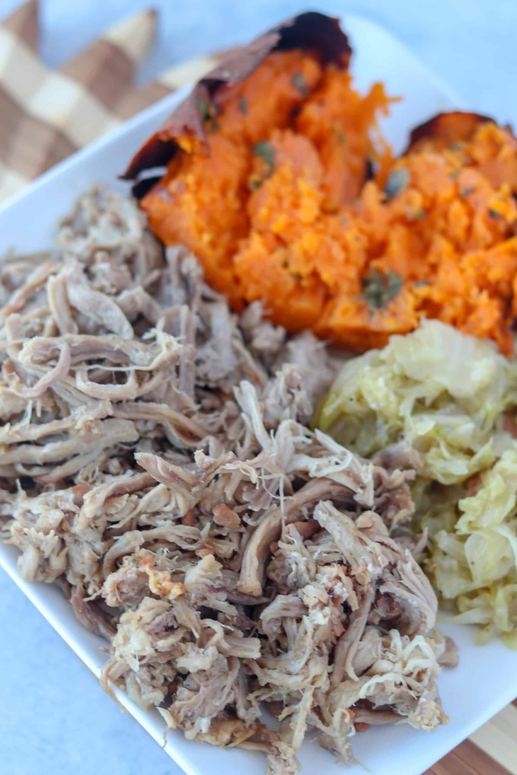 hawaiian pork on a plate with cabbage and sweet potatoes