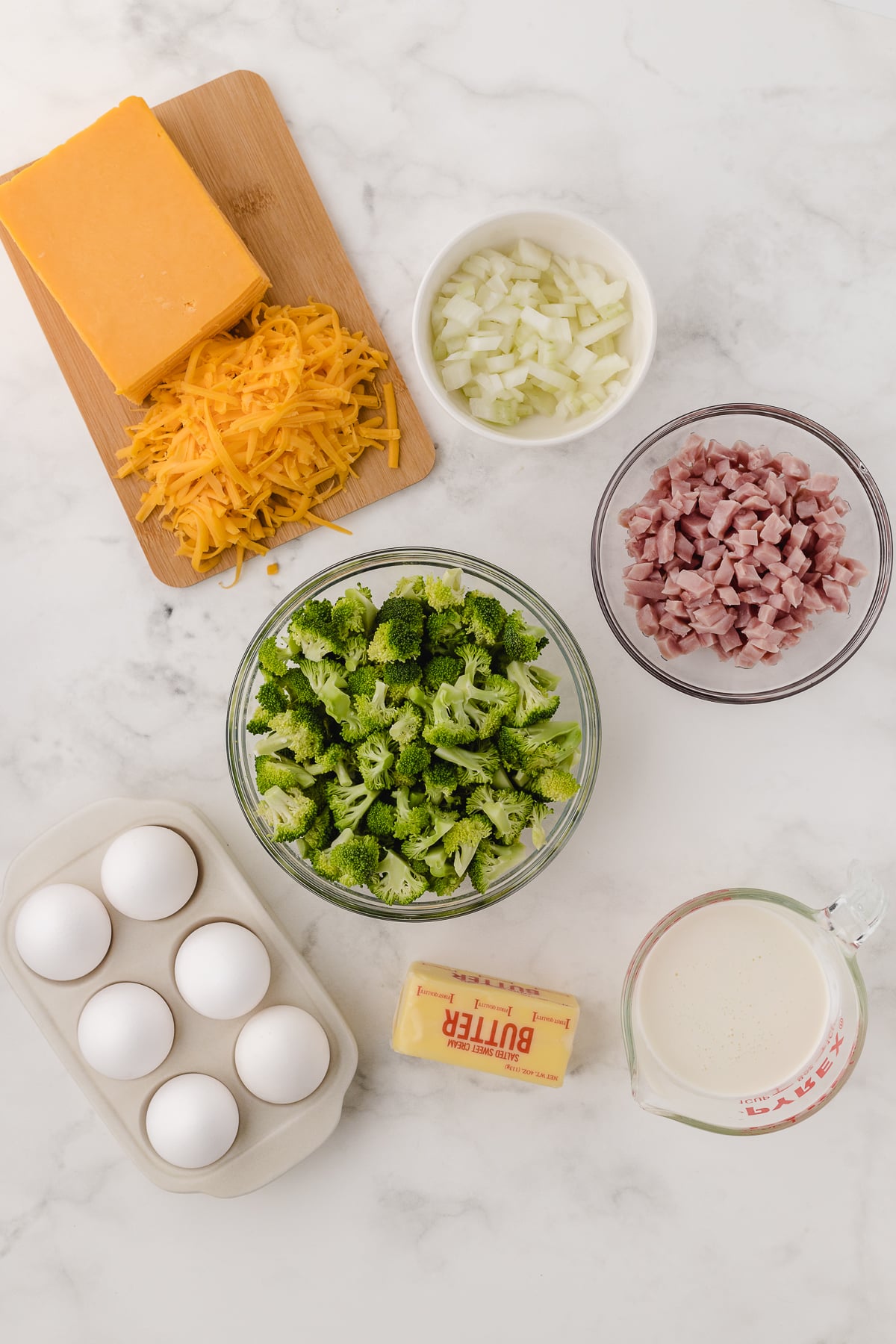 crustless quiche recipe ingredients on a white cutting board