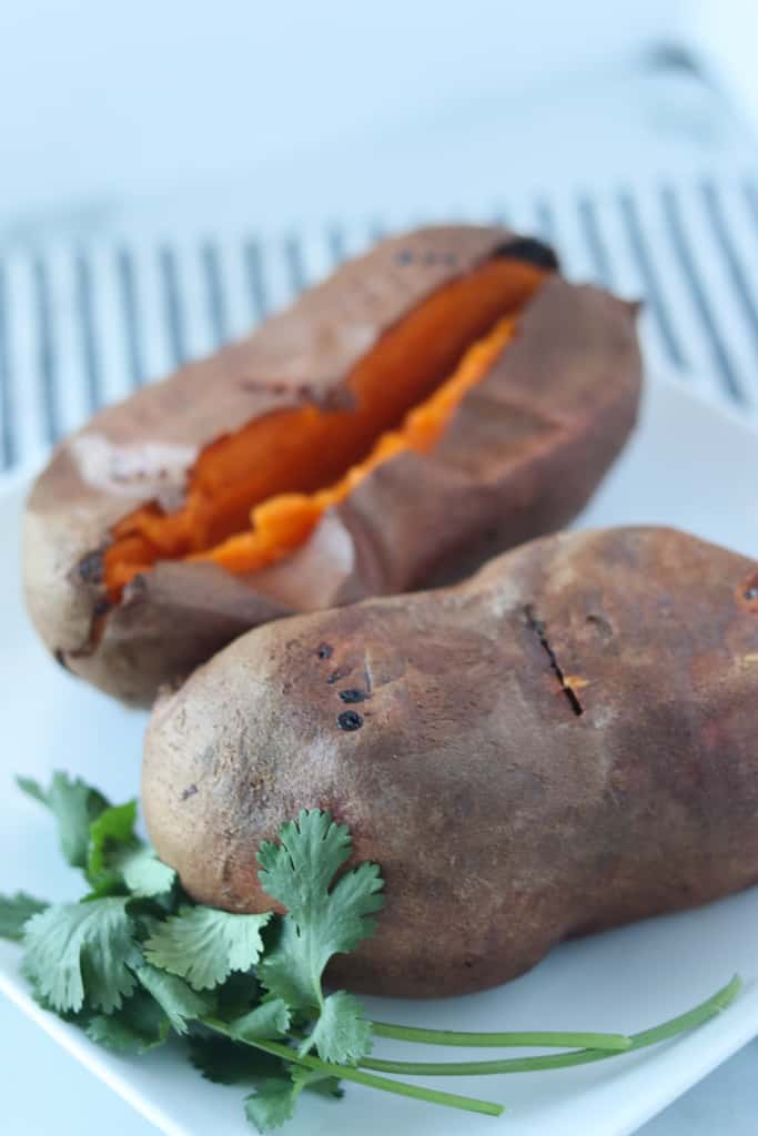 baked sweet potato in air fryer after cooking sitting on a white plate