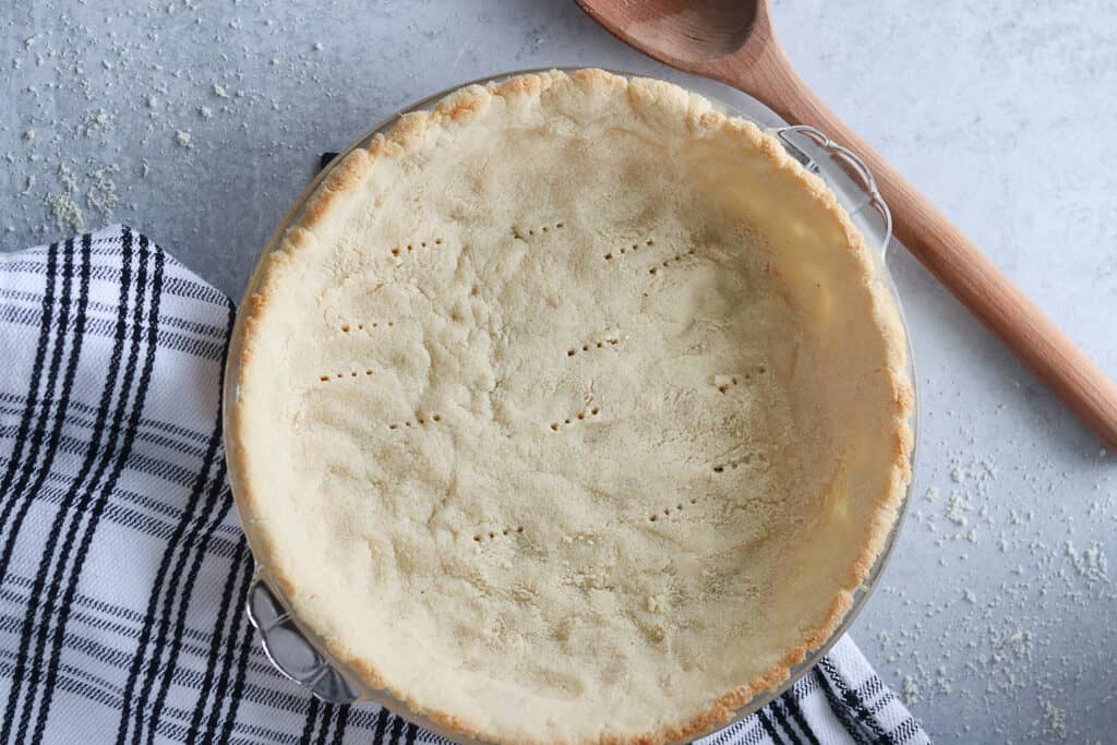 almond and coconut flour pie crust after baking on a gray background
