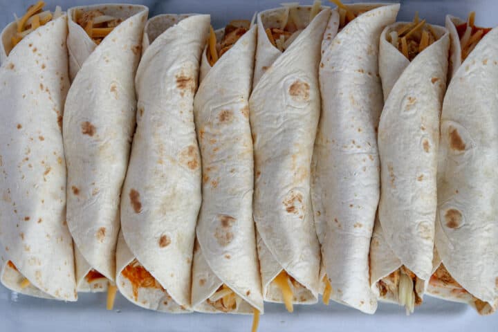 put the rolled up tortillas in a pan for this keto chicken enchilada recipe