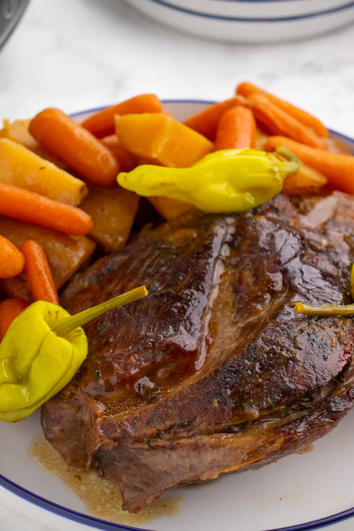 Mississippi pot roast with vegetables on a platter before shredding the meat