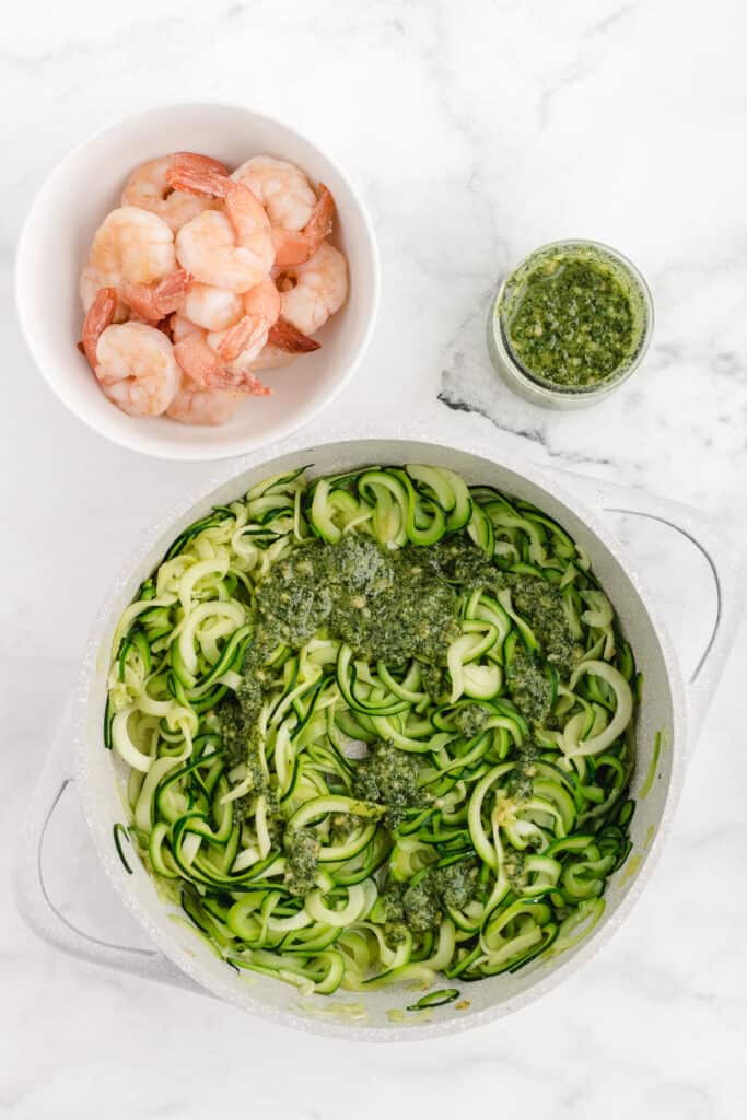 shrimp and zucchini noodles getting cooked in a skillet
