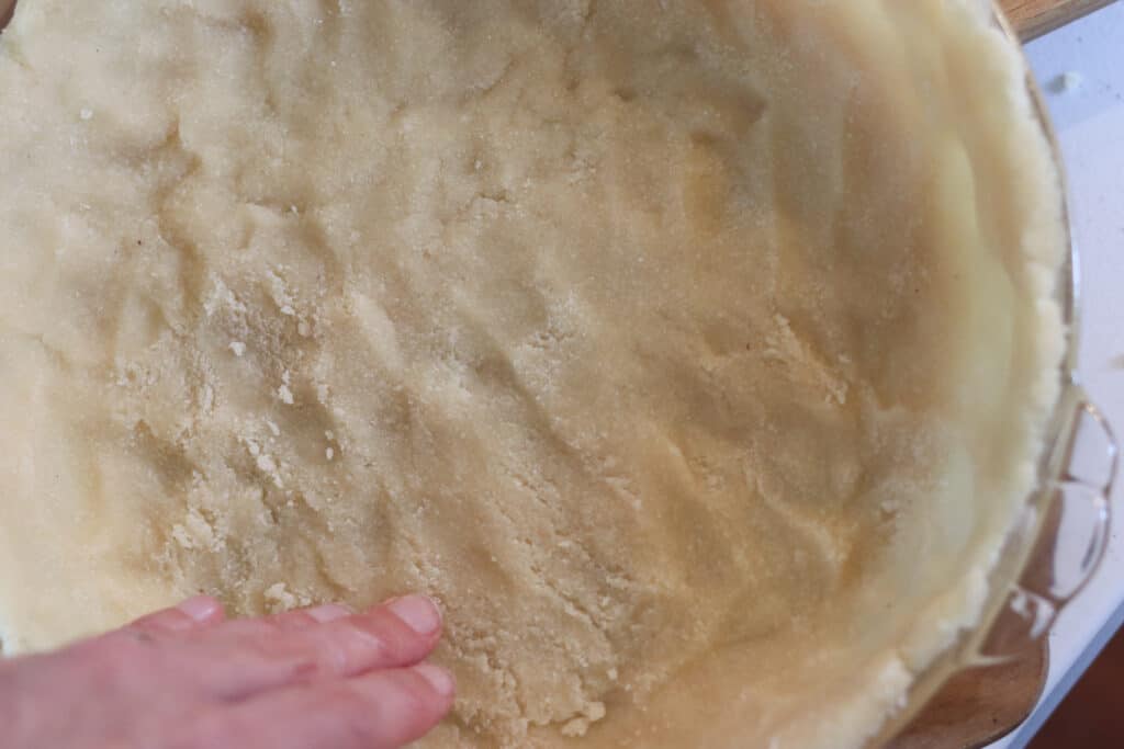 pressing the no roll low carb pie crust recipe into the pan
