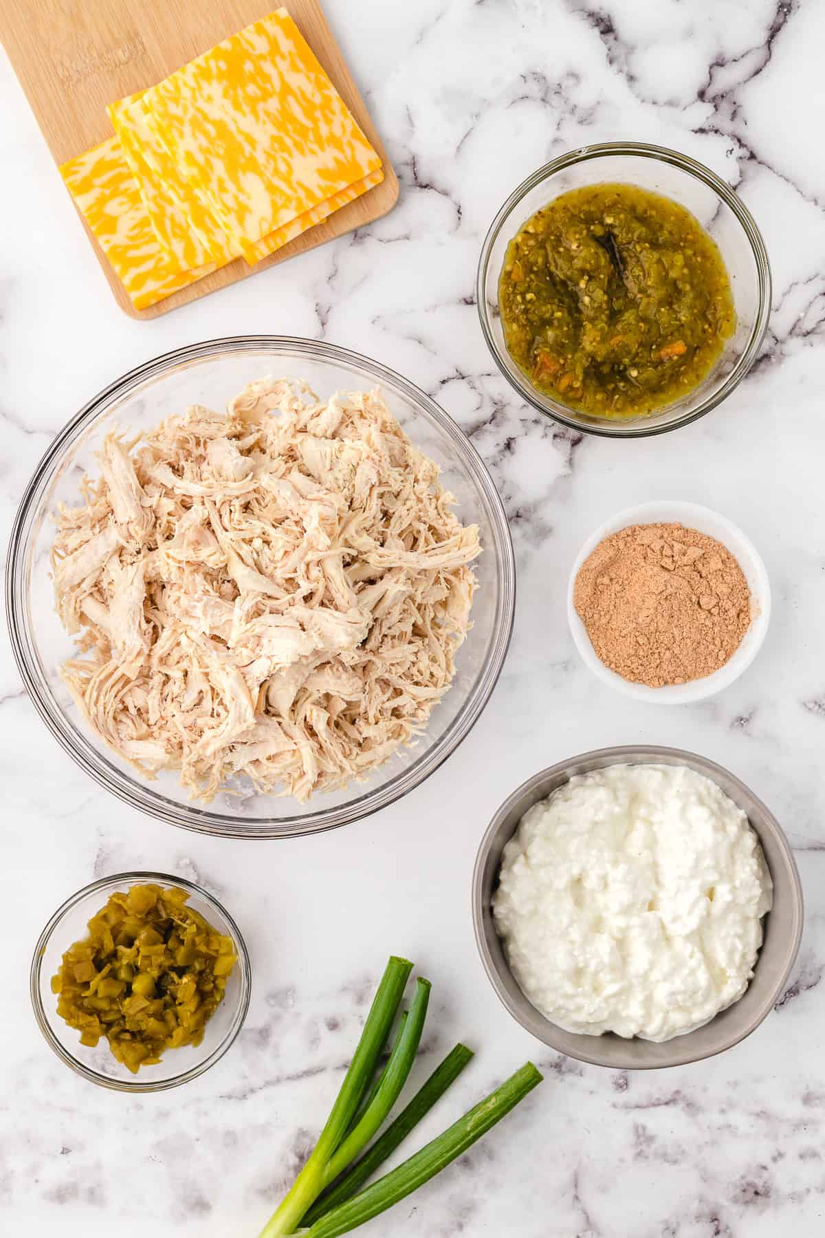 green chili chicken ingredients on a marble cutting board